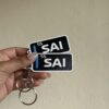 246e03cd-8a1b-4184-9347-d2ae400a5dc6-72276-000043615216bd87_file Sainz Race Tag Keychain
